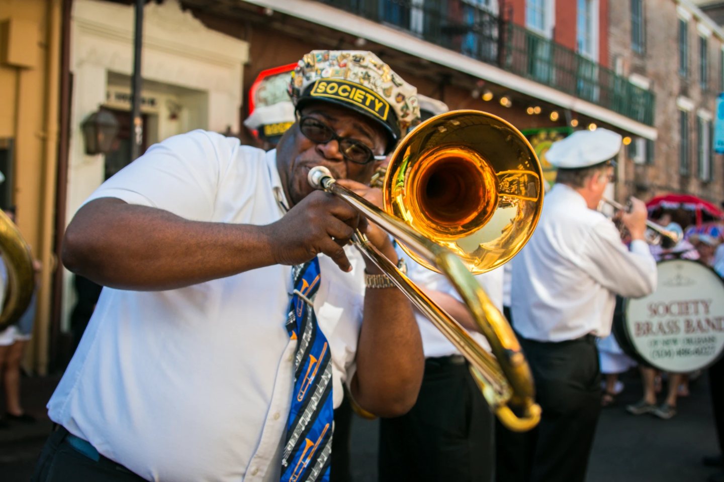 A brass band trombonist playing on a French Quarter street