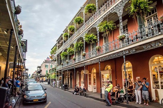Musicians playing on a French Quarter street lined with iron balconies